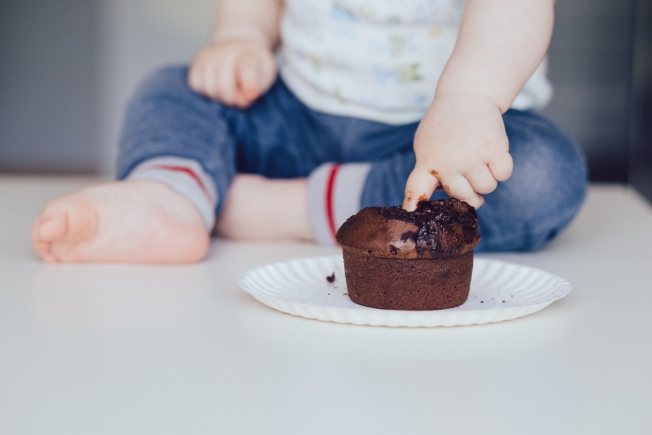 [IMAGE: A kid smushing a cupcake.]